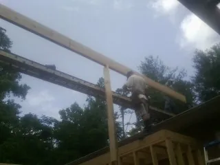 Carpenter setting a ridge beam over a new addition frame — Ice Dam Removal by Roofing Brothers in Lagunitas